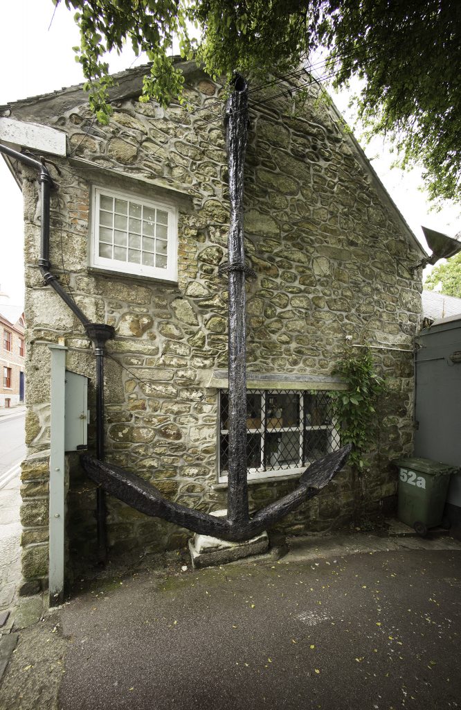 Gable end of a stone-built house with a large iron anchor fastened to the wall